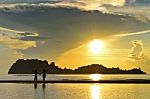 Two Children Standing On The Beach Watching The Sunrise Stock Photo