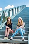 Two Dutch Girls Sitting On Metal Bridge Stock Photo