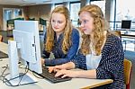 Two Female Students Working Together On Computer In Classroom Stock Photo