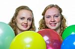 Two Girls Behind Various Colored Balloons Stock Photo