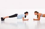 Two Happy Young Woman Doing Push-ups In Gym Stock Photo