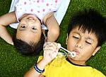 Two Kids Lying And Playing Stock Photo