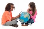 Two Little Girls Exploring A Globe Stock Photo