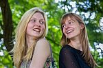 Two Long-haired Girls Laughing To Each Other Stock Photo