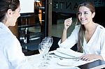 Two Smiling Business Women Have Dinner At Restaurant Stock Photo