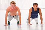 Two Young Man Doing Push-ups In Gym Stock Photo