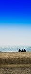 Vertical Three Freinds Sitting On The Ocean Beach Background Bac Stock Photo