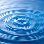 Water Drop Falling Into Water Making A Perfect Droplet Splash Stock Photo