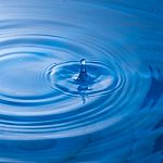 Water Drop Falling Into Water Making A Perfect Droplet Splash Stock Photo