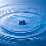 Water Drop Impact With Water Surface, Causing Rings On The Surface Stock Photo