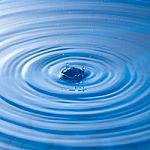 Water Drop Impact With Water Surface, Causing Rings On The Surface Stock Photo
