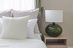 White Pillows On Bed With Modern White Lamp On Wooden Table Side Stock Photo