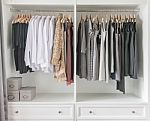 White Wardrobe With Clothes Hanging Stock Photo