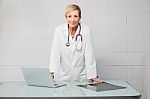 Woman Doctor Standing Behind Desk Stock Photo