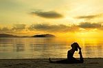 Woman Doing Yoga On The Beach Stock Photo