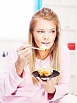 Woman Eating Cake At Home Stock Photo