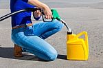 Woman Filling Yellow Can With Gasoline Or Petrol Stock Photo