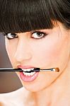 Woman Hold Make Up Brush Between Teeth Stock Photo