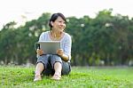 Woman Holding Tablet In Park Stock Photo