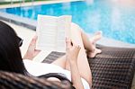 Woman In Summer Hat Reading A Book Near The Water Pool Wearing A Stock Photo