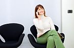 Woman In Waiting Room Talking On Phone Stock Photo