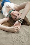 Woman Lying At The Beach With Sand Background Stock Photo