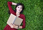 Woman Lying On Grass With  Book Stock Photo