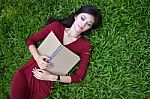 Woman Lying On Green Grass With  Book Stock Photo