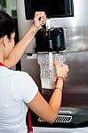 Woman Operating Machine To Pour Thick Shake Stock Photo