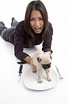 Woman Putting Puppy In Plate Stock Photo