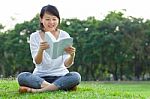 Woman Reading Book In Park Stock Photo