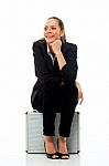 Woman Sitting On Briefcase Stock Photo