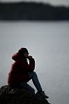 Silhouette Of A Speculating Woman On A Rock Stock Photo