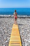 Woman Standing On Wooden Path At  Sea Stock Photo