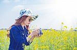 Woman Taking Photos At A Rapeseed Flowers. Vintage Tone Style Stock Photo