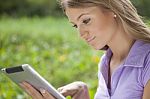 Woman Using Tablet Computer In Park Stock Photo