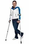 Woman Walking With The Support Of Crutches Stock Photo