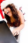 Woman Wearing Christmas Hat And Working On Laptop Stock Photo