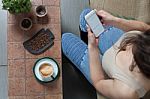 Woman With Coffee Cup On Ceramic Table And Mobile Phone Stock Photo