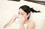 Woman With Cold Sneezing Into Tissue Stock Photo