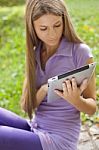 Woman With Tablet Computer In Park Stock Photo