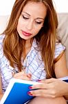 Woman Writing In Notepad Stock Photo