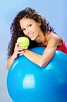 Women Behind Blue Pilates Ball Holding Green Apple Stock Photo