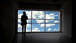 Women Silhouette Beside The Big Window And Sky Background Stock Photo