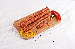 Wooden Chopping Board With Sausages And Spices Stock Photo