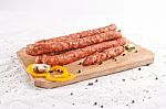 Wooden Chopping Board With Sausages And Spices Stock Photo