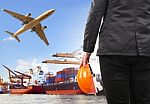 Working Man And Commercial Ship On Port And Air Cargo Plane Flyi Stock Photo