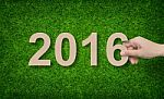 Year 2016 - Hand Holding Paper Alphabet Number On Green Grass Stock Photo