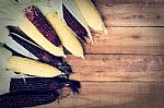 Yellow And Red Corns Are On Wooden Table Stock Photo