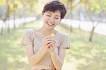 Young And Beautiful Woman Laughing To Little Flowers In Hand Wit Stock Photo